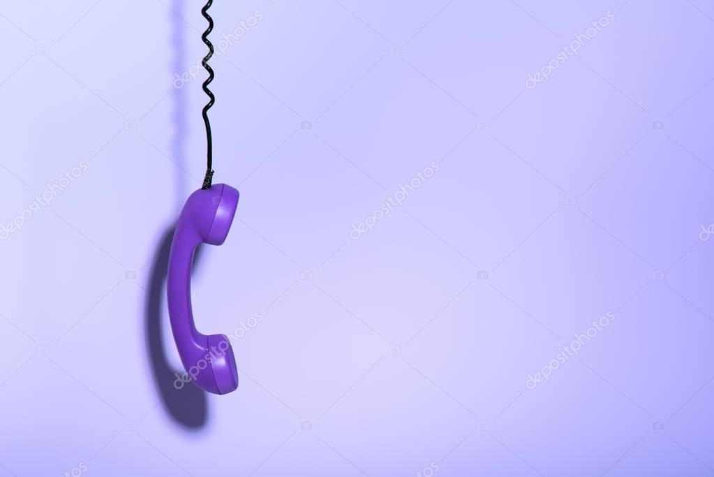 Schwarzes Wählscheibentelefon auf einem Holztisch